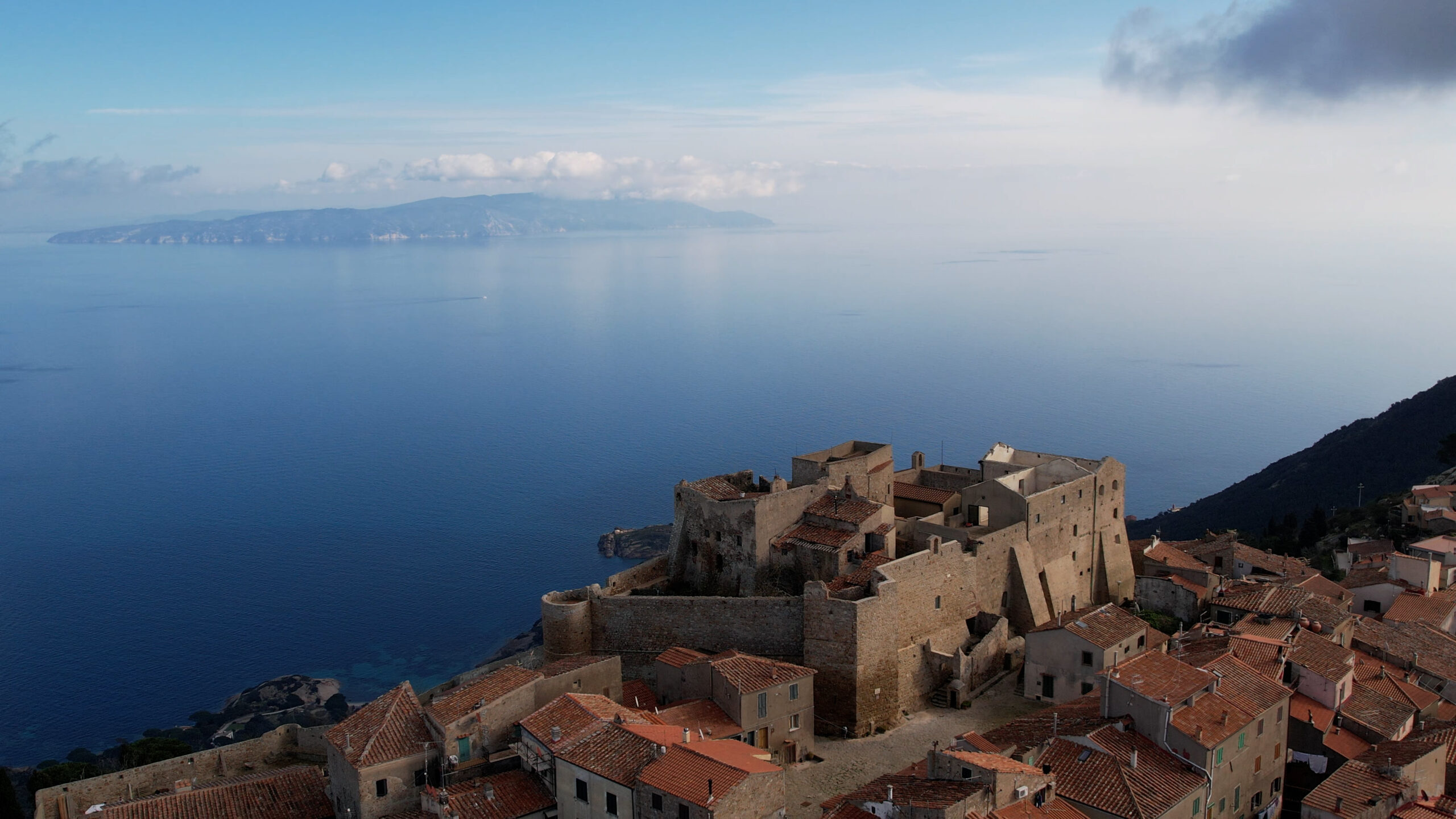 L'immagine mostra il borgo fortificato di Giglio Castello con parte di paese.