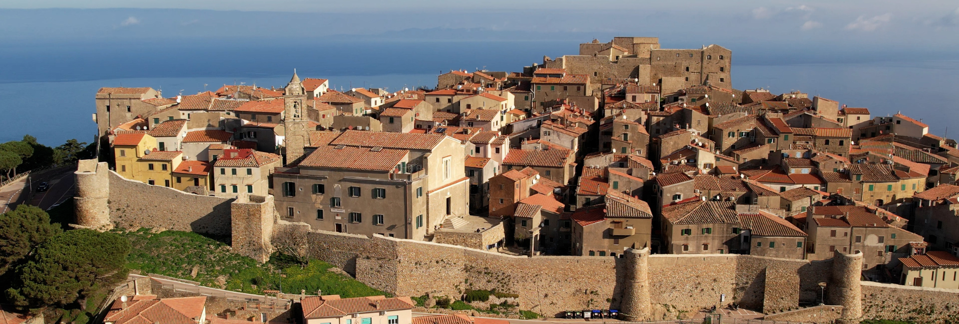 Immagine del borgo che è situato sulla cima di una collina e circondato da antiche mura di pietra.