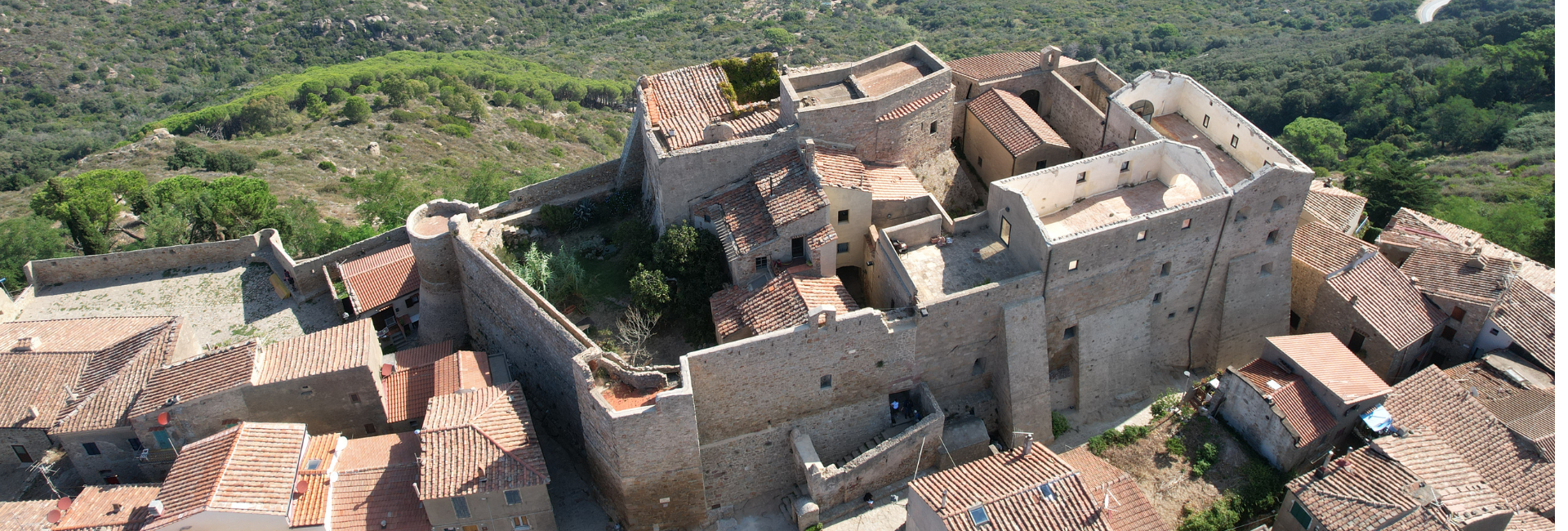 La foto mostra un'aerea di Giglio Castello recintato dalle mura.