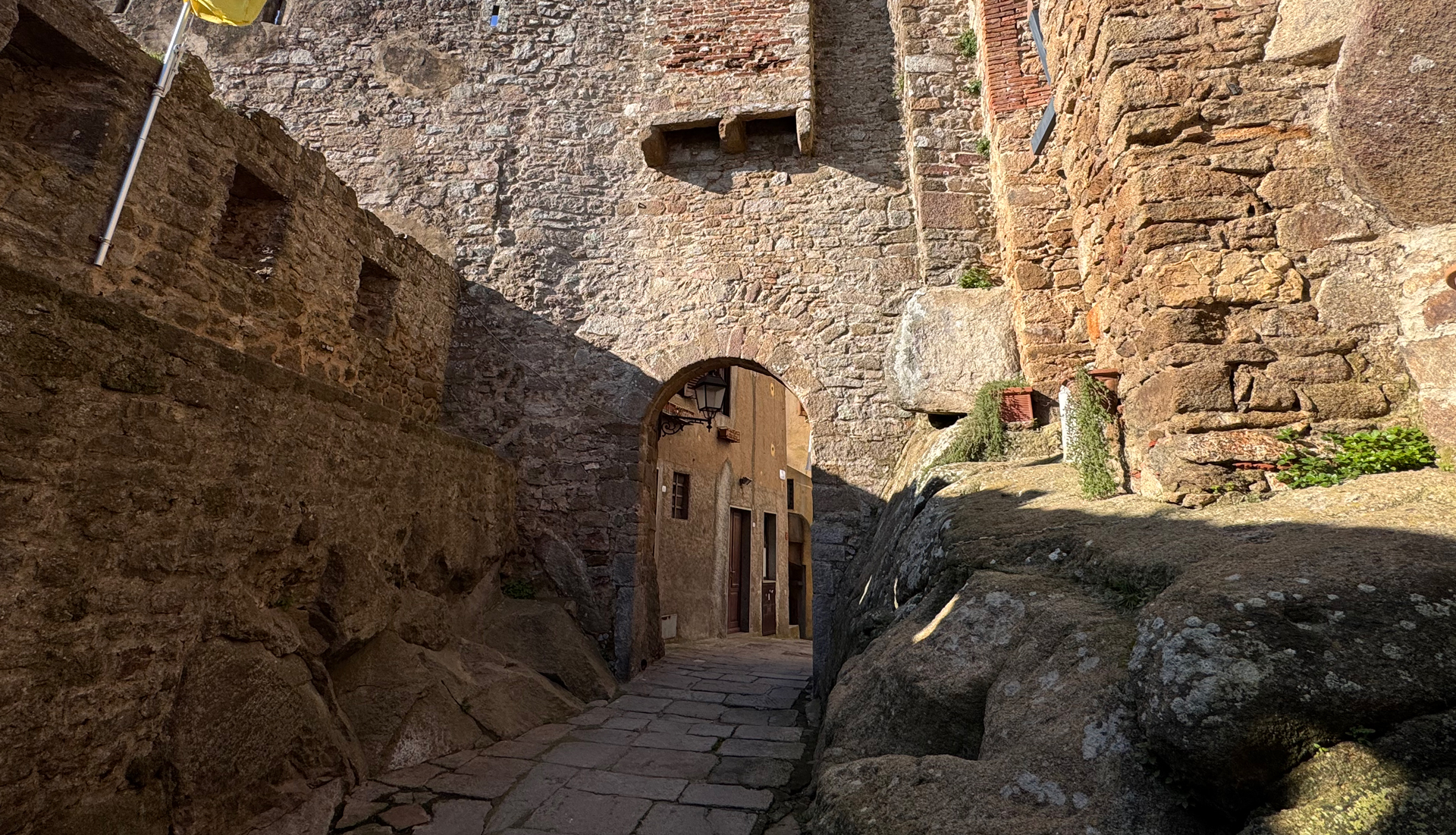 L'immagine mostra un arco in pietra come fosse un ingresso.