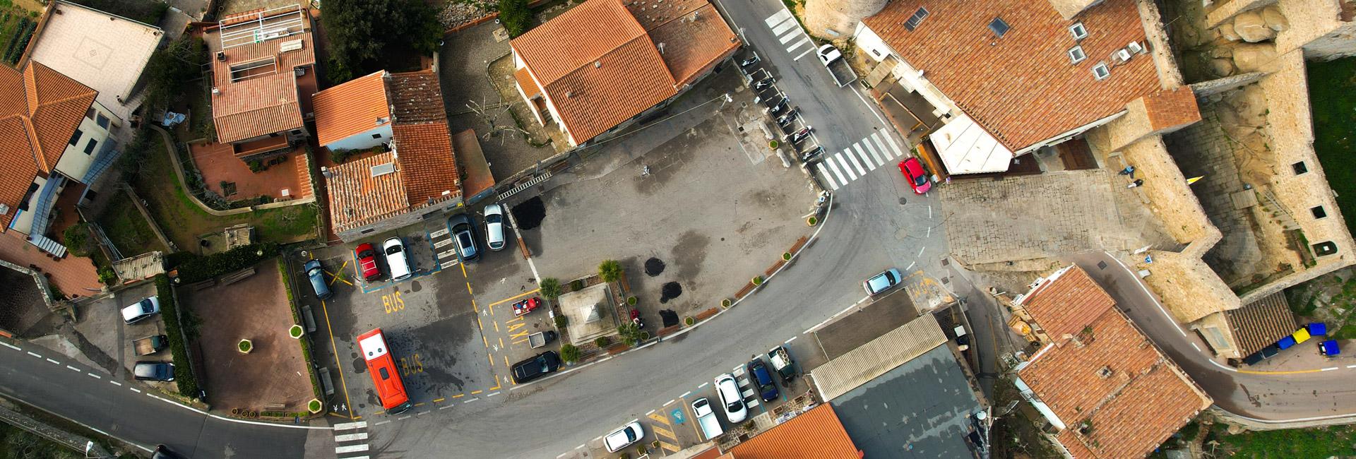 L'immagine è una veduta aerea del piccolo borgo, caratterizzato da edifici con tetti di tegole e strade che si snodano tra le case.